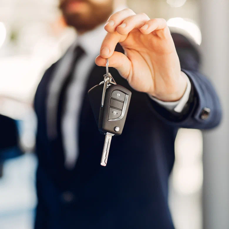 Client standing next to a vehicle at a dealership